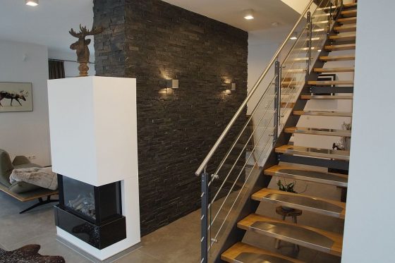 Die Treppe nach oben besteht aus Stahl, Glas und Holz und fügt sich so hervorragend in das Interieur-Design des Hauses ein. (Foto: OKAL Haus GmbH / Markus Burgdorf)